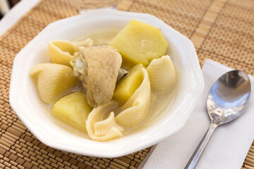 chicken broth soup with chicken, potatoes, and pasta shells