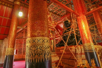 view of black buddha statue in buddhist temple cover with black patina being gild new gold plate, Wat Phumin, Nan Province, northern of Thailand.