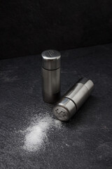 Salt and pepper in metal shakers.