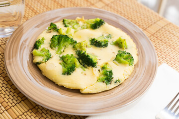 wholesome breakfast. omelet with broccoli on brown plate