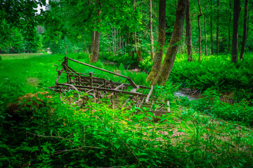 Alte benutzte und rostige Egge am Rand einer Waldlichtung im bayerischen Wald