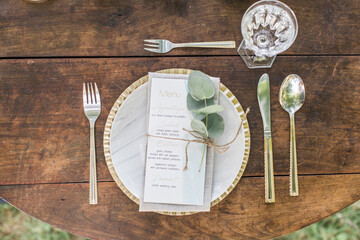 Boho wedding dinner reception table set up. Top view, eucalyptus, gold and blue decoration, wooden background, flat lay