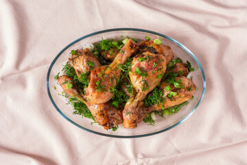 Baked chicken drumsticks with rosemary, spices, onions and dill on a wooden background , top view