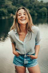 Girl smiling in a natural and calm landscape.