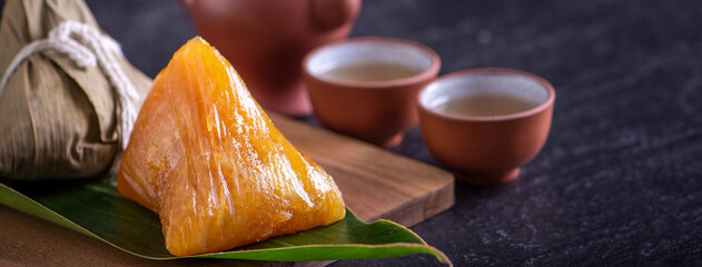 Alkaline rice dumpling zongzi - Traditional sweet Chinese crystal food on a plate to eat for Dragon Boat Duanwu Festival celebration concept, close up.