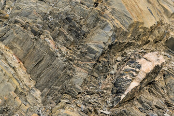 Mountain stone. Macro photo. Rough texture of mountain wild stone. Rough surface of an ancient mountain. Grunge texture. Laminated surface. Abstract grunge background. Marble. Granite. 