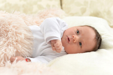 Portrait of cute little baby boy on bed