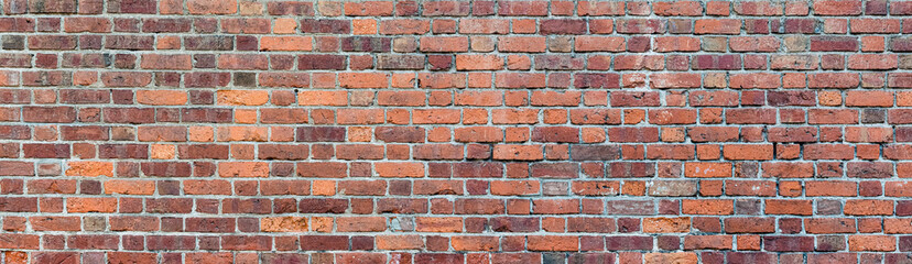 panorama of shabby brick wall. wall of red and brown bricks. building background.