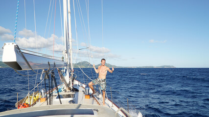 Male sailor on a yacht sail boats on the shore in Antigua in the Caribbean island nation Antigua...