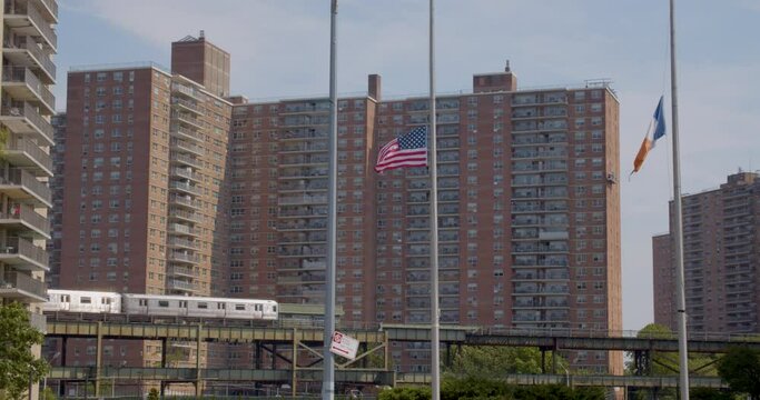 New York City and USA flags in wind while train passes behind