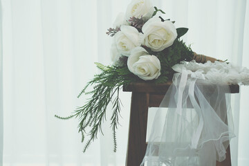 wedding white bridal veil & rose flower bouquet on wooden chair
