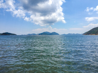 A sea in Hong Kong, turquoise, and bright blue sky There is a mountain in the back. Giving a fresh feeling in the morning