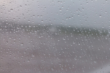 The raindrops are attached to the clear glass in front of the car. When it rains During the day time, the picture is partially clear.