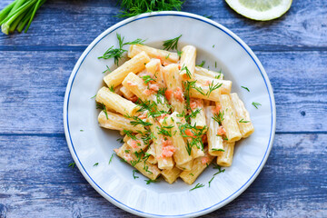  Italian home made  macaroni pasta with smoked salmon , creamy sauce and fresh dill on wooden background