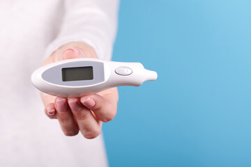 Electronic thermometer in hands.