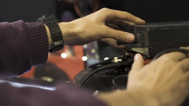 Side view of a hand inserting a wire into the switch. Stock footage. Close up of sound setting process, male hands adjusting the controls of the professional equipment.