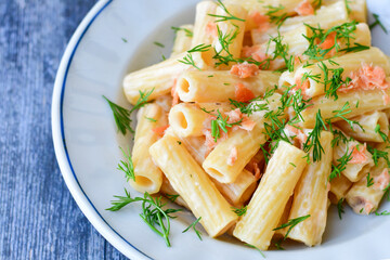  Italian home made  macaroni pasta with smoked salmon , creamy sauce and fresh dill on wooden background