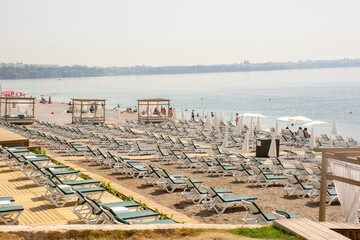 The tourist season is open, very few tourists have arrived, there are many empty sunbeds and beach chairs. Konyaalti Beach, Antalya, Turkey.