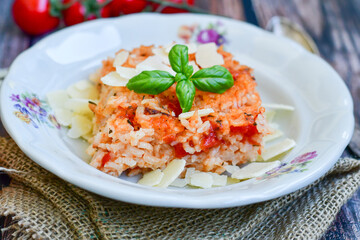 Home made italian oven baked tomato risotto  with a fresh leaf of basil and parmesan cheese 