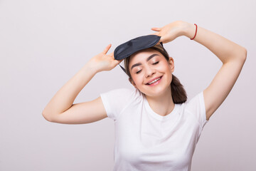 Smiling young woman with sleep mask isolated on white background Healthy sleep concept.