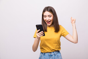 Naklejka premium Successful happy woman holding mobile phone isolated on a white background