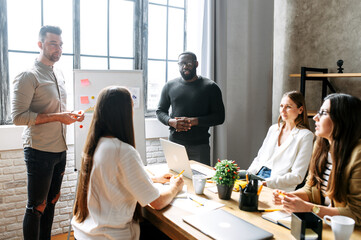 Discussion of successful multiracial team during a morning meeting at the office. Brainstorming in a multiracial team in office.