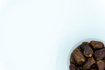Dates in plastic container over white background