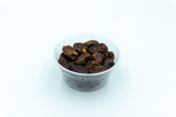 Dates in plastic container over white background