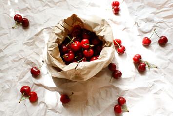 Cherries in a paper bag on a paper background