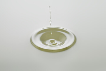 Dripping colorless oil on white background.