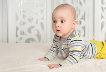 Portrait of cute little baby boy on bed