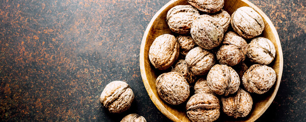 Whole walnuts on dark stone concrete table background. Copy space. Healhty Vegetarian Vegan Food Concept