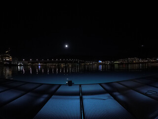tromsoe bridge with blue cathedral and illuminated sea at night