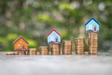 Money Financial, Business Growth,loan and real estate investment concept. house model on gold coins to stack of coins.