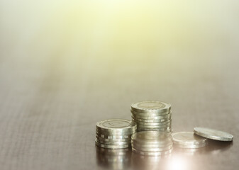 The close-up rows of money coins on desk with a blurred background
