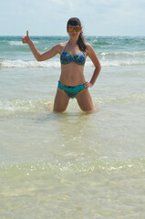 Fototapeta premium Young millennial girl in a swimsuit is having fun and enjoying life on vacation at the sea