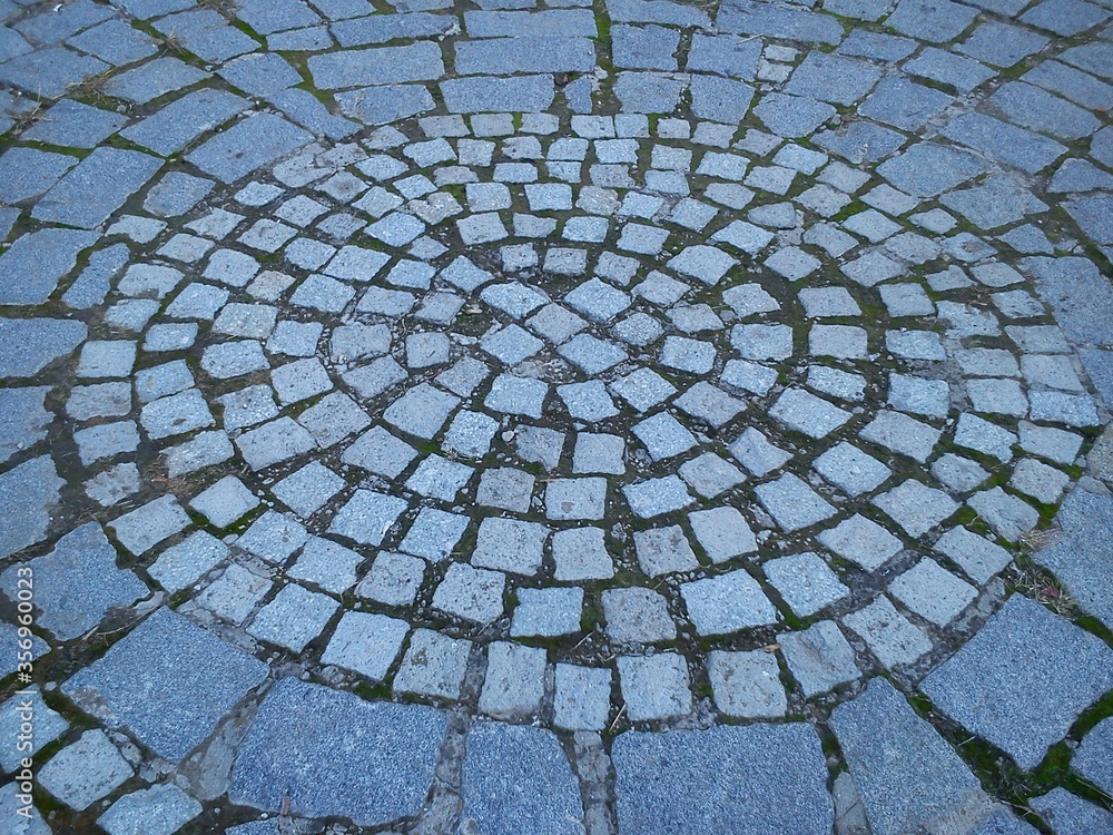 Poster rounded cobblestone mosaic. cobblestone paved with stones in a circle.