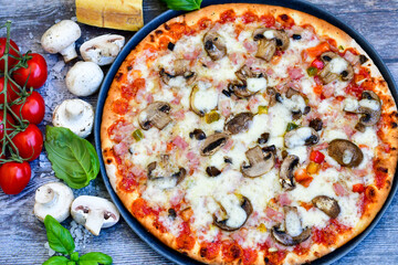  Close up of    hot italian pizza   classic ham. Fresh basil,tomato sauce ,mozzarella cheese , mushrooms and  minced meat .Concept poster for Restaurants or pizzerias. Top view