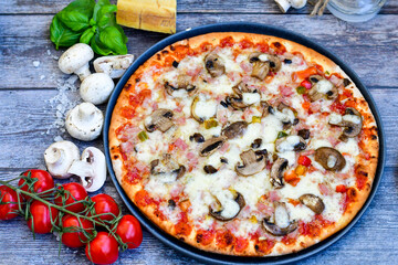  Close up of    hot italian pizza   classic ham. Fresh basil,tomato sauce ,mozzarella cheese , mushrooms and  minced meat .Concept poster for Restaurants or pizzerias. Top view