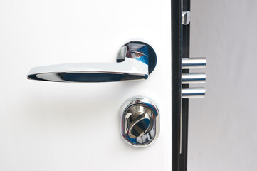 Glossy white interior entrance metal door with details: handle, open closed lock, hinges and...