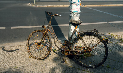 altes rostiges Fahrrad steht am Strassenrand in Berlin