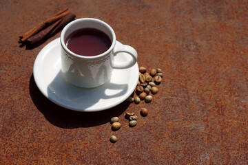 Flat lay Coffee composition  with  white cup  of red coffee and beans of coffe on iron  rustic
