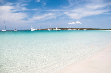Fantastic deserted beach with transparent water and white sand, in the background the quiet bay, an ideal place to anchor the boat. Formentera, Balearic Islands, Spain