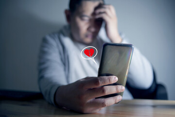 Sad man being dumped on phone by her woman, broken heart concept, crying in dark