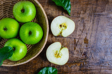 Green apple in a basket on a wooden table