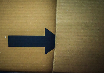 black arrow on a cardboard shipping box for advertisement.