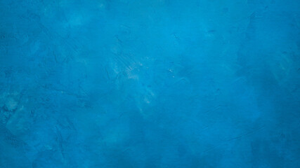 A blue cent wall textured background with small cracks. 