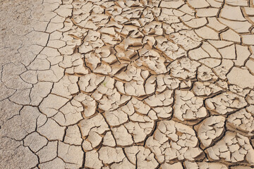 Natural Drought concept:Dried cracked earth soil ground texture background.desert rough land dry crack erosion in the ground due to drought.Dry red clay soil texture, natural floor background