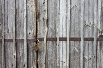 Closed garage wooden door of old garage and old hinged lock