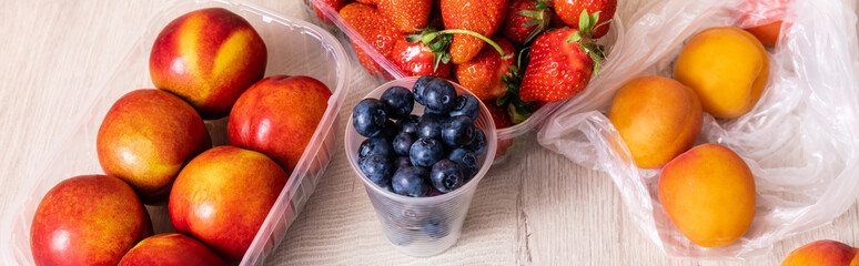 fruit composition with blueberries, strawberries, nectarines and peaches in plastic containers on...